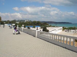 Passeggiata pedonale con ringhiera bianca e vista sul mare in Tunisia, persona seduta su panchina de La Marsa Tunisi